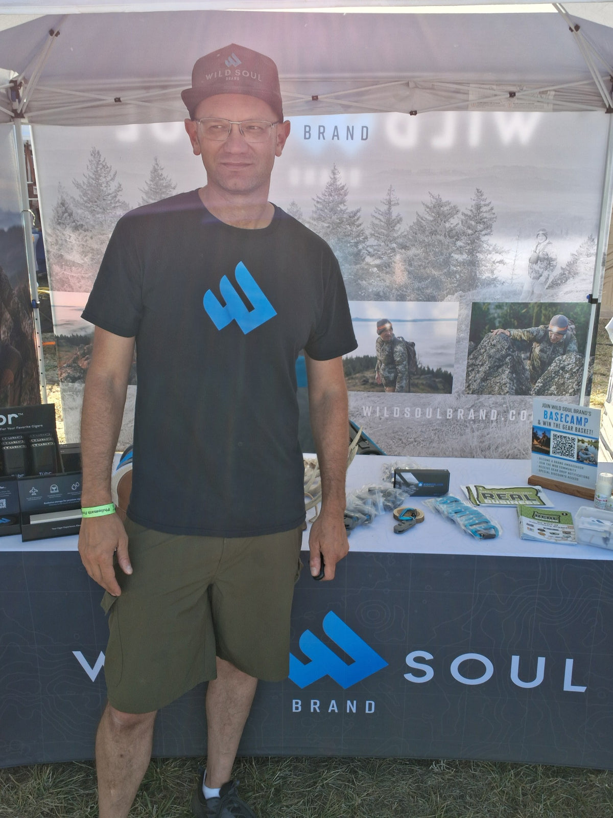 Founder in a Wild Soul shirt standing in front of the Wild Soul Brand event booth