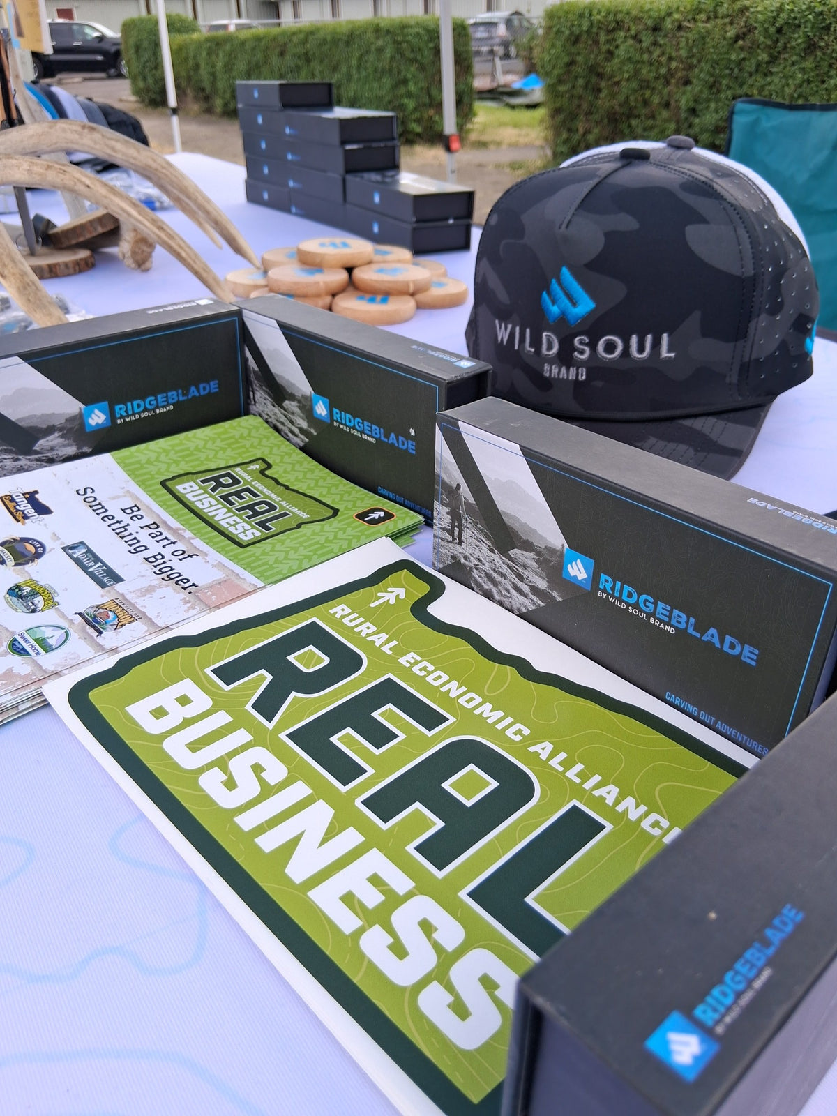 Ridgeblade boxes and a Wild Soul Brand hat on a Rural Economic Alliance REAL Business table
