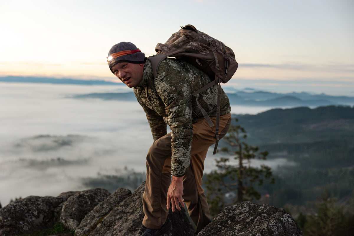 Ridgeblade folding pocket knife and its gift box on a picnic table at a campsite, with a tent and campfire behind