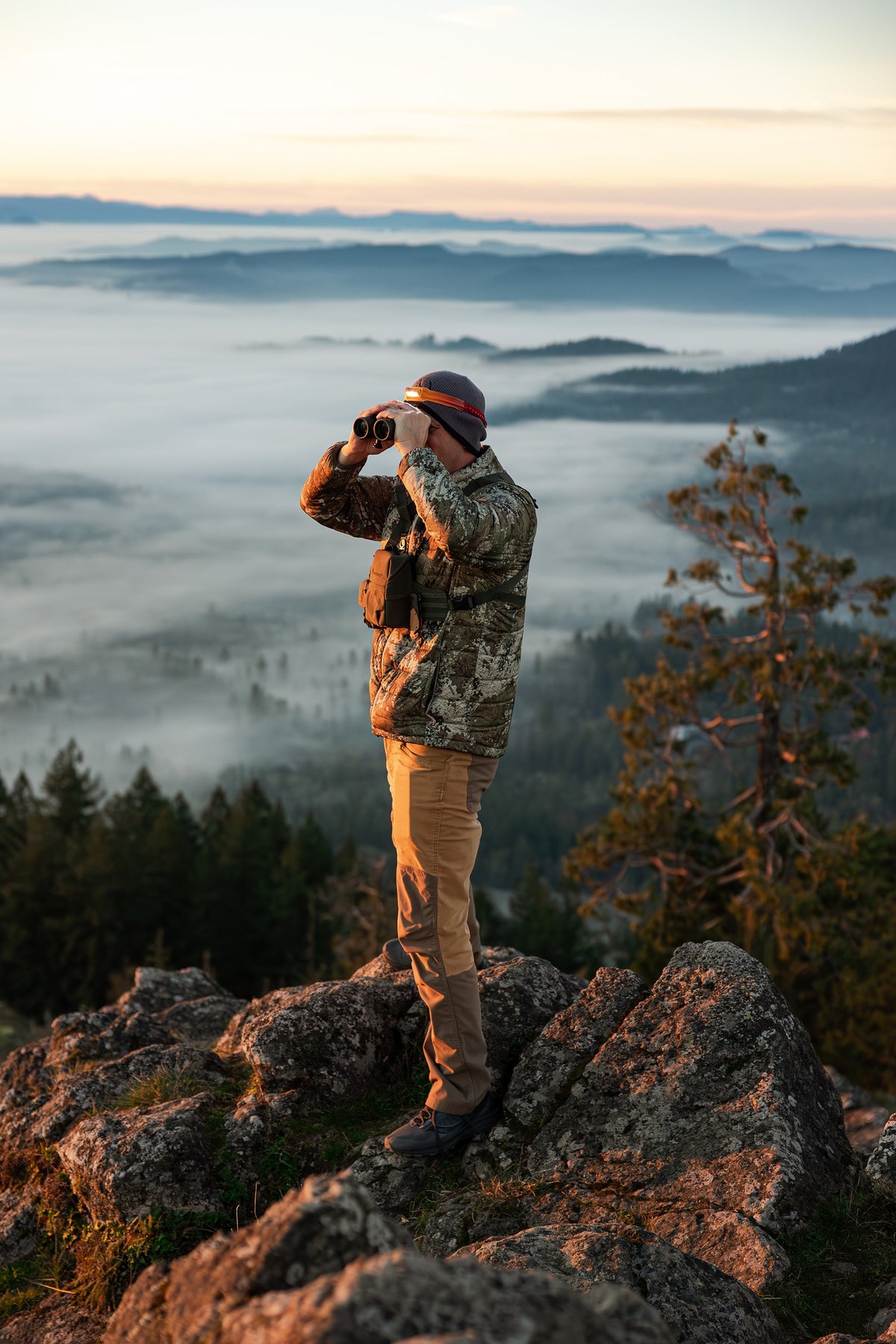 Man sitting by a campfire at dusk holding a Ridgeblade folding knife