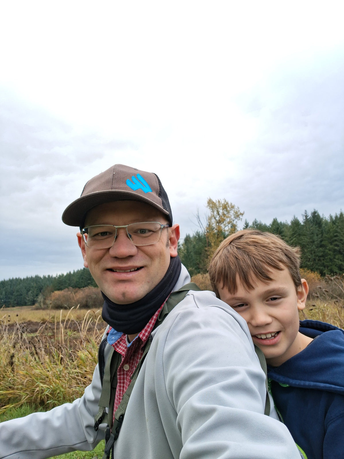 Founder and his son hugging outdoors beside a marsh