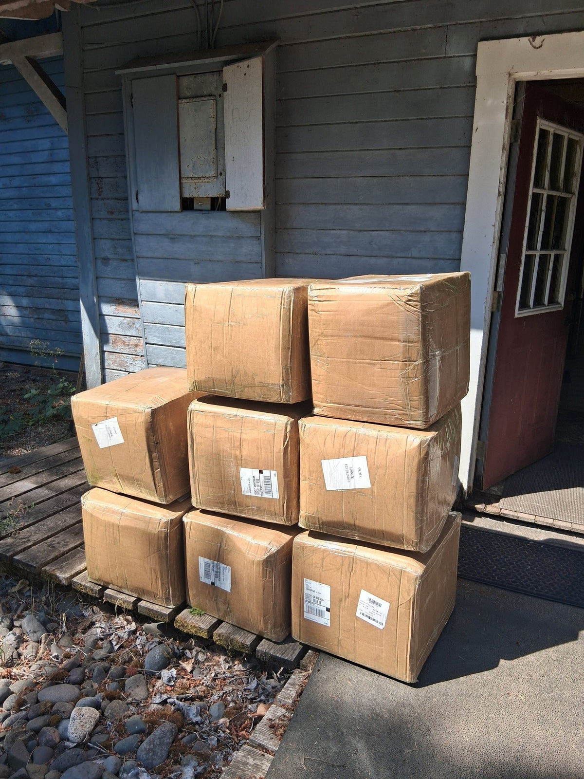 Stack of shipping boxes of Wild Soul Brand inventory outside a cabin